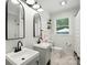 Bright bathroom featuring a double vanity with modern fixtures, white walls, and natural light from the window at 103 W Sunset Dr, Locust, NC 28097