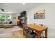 Open-concept dining area with wood table and direct access to the living room and fireplace at 103 W Sunset Dr, Locust, NC 28097