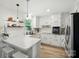 Bright white kitchen featuring modern appliances, subway tile backsplash, and stylish pendant lighting at 103 W Sunset Dr, Locust, NC 28097