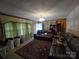 Inviting living room with wood paneling, comfortable leather seating, and a classic ceiling light fixture at 116 E Graves St, Candor, NC 27229