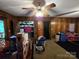 Living room featuring vintage ceiling fan, wood paneling and access to exterior at 116 E Graves St, Candor, NC 27229