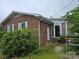 Side view of a brick house features a functional entrance and well-kept surroundings at 116 E Graves St, Candor, NC 27229