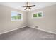Inviting bedroom with neutral carpet, a ceiling fan, and natural light from two windows, creating a comfortable and serene space at 119 Oak Ave, Shelby, NC 28152