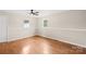 Cozy bedroom with hardwood floors, a ceiling fan, neutral walls, and two windows providing ample natural light at 119 Oak Ave, Shelby, NC 28152