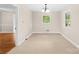 Cozy dining room with neutral carpet, a chandelier, and natural light from two windows offering a comfortable and inviting atmosphere at 119 Oak Ave, Shelby, NC 28152