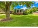 Charming home with a well-manicured lawn, mature tree, and a cozy sunroom for relaxing at 119 Oak Ave, Shelby, NC 28152
