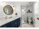 Bright bathroom with white walls, a modern sink with round mirror, and a glass-door shower at 138 Lakefront Dr, Mooresville, NC 28117