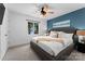Cozy bedroom featuring a king-size bed with a blue accent wall and scenic window view at 138 Lakefront Dr, Mooresville, NC 28117