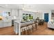 Bright, modern kitchen with white cabinets, island seating, and hardwood floors overlooks a beautiful outdoor view at 138 Lakefront Dr, Mooresville, NC 28117