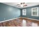 An empty bedroom featuring hardwood floors, two windows, and blue-painted walls at 139 Pleasant Garden Dr, Taylorsville, NC 28681