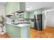 Quaint kitchen featuring updated appliances, light green cabinetry, and hardwood floors at 139 Pleasant Garden Dr, Taylorsville, NC 28681