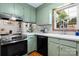 A charming kitchen features light green cabinets, quartz countertops, and stainless steel range at 139 Pleasant Garden Dr, Taylorsville, NC 28681