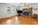 Cozy living room featuring hardwood floors, a stone fireplace, and a bright window for natural light at 139 Pleasant Garden Dr, Taylorsville, NC 28681