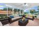 A sunroom with neutral colored furniture, including two couches, a glass table, and a view of the backyard at 139 Pleasant Garden Dr, Taylorsville, NC 28681