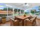 This sunroom features hardwood floors, is surrounded by windows, and features a wooden table at 139 Pleasant Garden Dr, Taylorsville, NC 28681