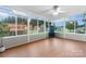 A bright sunroom with hardwood floors, multiple windows, and a view of the deck and backyard at 139 Pleasant Garden Dr, Taylorsville, NC 28681