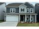Charming two-story home featuring a stone facade, two-car garage, and inviting front porch at 1431 Hubert Graham Way, Tega Cay, SC 29708