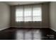 Bedroom with large windows, sheer curtains, and dark hardwood floors at 147 Dubois Dr, Mooresville, NC 28115