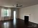 Spacious living room with a fireplace, ceiling fan, and natural light at 147 Dubois Dr, Mooresville, NC 28115