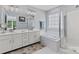 Bright bathroom with a tub, a glass shower, and double sinks at 16018 Hollingbourne Rd, Huntersville, NC 28078