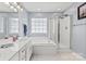 Bright bathroom featuring double sinks, a glass shower and tub at 16018 Hollingbourne Rd, Huntersville, NC 28078