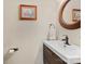 This bathroom features a wooden mirror, a sink with dark cabinetry and bronze fixtures at 16018 Hollingbourne Rd, Huntersville, NC 28078