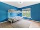 Cozy room with blue walls and a metal bunk bed by a window with exterior views at 16018 Hollingbourne Rd, Huntersville, NC 28078