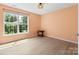 Bright bedroom featuring a large window, light walls and flooring, and a small round accent table at 16018 Hollingbourne Rd, Huntersville, NC 28078