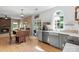 Open floor plan featuring a stone fireplace, dining area, and kitchen with hardwood flooring at 16018 Hollingbourne Rd, Huntersville, NC 28078
