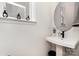 Contemporary half bathroom featuring a pedestal sink, modern fixtures, and neutral decor, providing a clean and stylish look at 16018 River Tree Ln, Charlotte, NC 28278