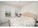 Bright bedroom featuring a floral bedspread, plush headboard, and well-lit with two windows at 16018 River Tree Ln, Charlotte, NC 28278