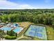 Aerial view showcasing community pools, tennis courts, and surrounding wooded area at 16028 Cranleigh Dr, Huntersville, NC 28078
