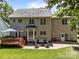 Spacious backyard with a wooden deck, brick patio, seating area, lush green lawn, and mature trees at 16028 Cranleigh Dr, Huntersville, NC 28078