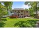 Large backyard with wooden deck, brick patio, outdoor seating, and lush lawn at 16028 Cranleigh Dr, Huntersville, NC 28078