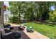 Brick patio area with outdoor seating and a fire pit surrounded by a lush green lawn at 16028 Cranleigh Dr, Huntersville, NC 28078