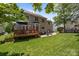 Expansive backyard with wooden deck, brick patio featuring seating, a lush green lawn, and mature trees at 16028 Cranleigh Dr, Huntersville, NC 28078