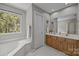 Bright bathroom with double vanity, garden tub, and a large window offering natural light at 16028 Cranleigh Dr, Huntersville, NC 28078