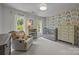 Bedroom showcasing cheerful rainbow wallpaper, a crib, dresser, and a cozy reading nook at 16028 Cranleigh Dr, Huntersville, NC 28078