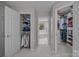 Hallway with access to well-organized walk-in closets and a glimpse into a bathroom with a tub at 16028 Cranleigh Dr, Huntersville, NC 28078