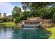 Community entrance with a stone waterfall, lush landscaping and signage at 16028 Cranleigh Dr, Huntersville, NC 28078