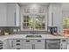 Bright and airy kitchen featuring a large sink, modern appliances, and a view of the backyard through the window at 16028 Cranleigh Dr, Huntersville, NC 28078