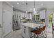 Modern kitchen with white cabinetry, stainless steel appliances, quartz countertops, and a center island with seating at 16028 Cranleigh Dr, Huntersville, NC 28078