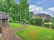 Landscaped backyard featuring a patio area with a fire pit and well-manicured lawn at 16308 Woolwine Rd, Charlotte, NC 28278