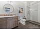 Modern bathroom with stylish vanity, toilet, and glass-enclosed walk-in shower with tile surround at 16308 Woolwine Rd, Charlotte, NC 28278