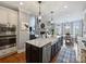 Open concept kitchen featuring stainless appliances, a breakfast bar, and seamless flow into the living and dining areas at 16308 Woolwine Rd, Charlotte, NC 28278