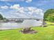 Picturesque view of the lake with boats docked, seen from a grassy area with benches at 16308 Woolwine Rd, Charlotte, NC 28278