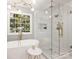 Bright main bathroom with a glass shower, soaking tub, and large windows at 16308 Woolwine Rd, Charlotte, NC 28278