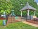 Community playground with a gazebo, slide, and climbing structure, surrounded by lush trees at 16308 Woolwine Rd, Charlotte, NC 28278