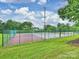 Outdoor tennis and basketball courts with green fencing, surrounded by trees and landscaping at 16308 Woolwine Rd, Charlotte, NC 28278