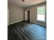A neutral bedroom with wood-look flooring, closet, and white trimmed window at 1987 Robert Rufty Ln, Catawba, NC 28609